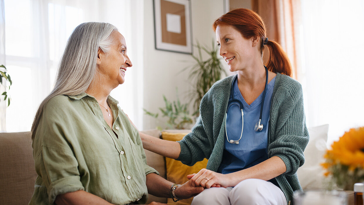 Aidante qui réconforte une personne âgée